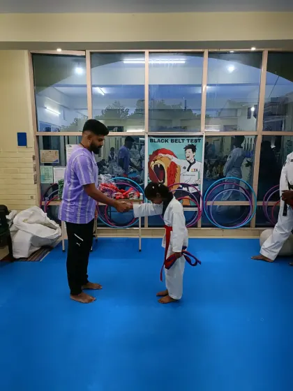 A young girl bows after receiving her red belt.
