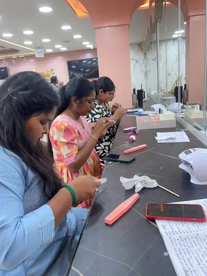 Students diligently practicing their nail application techniques at their individual stations.