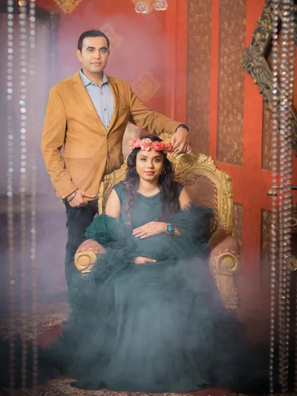 A dramatic, moody portrait of a couple in a studio setting. The use of smoke and elegant furniture creates a royal and timeless feel.