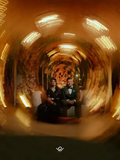 A creative and artistic shot using a slow shutter speed to create a swirling light tunnel effect around the couple.