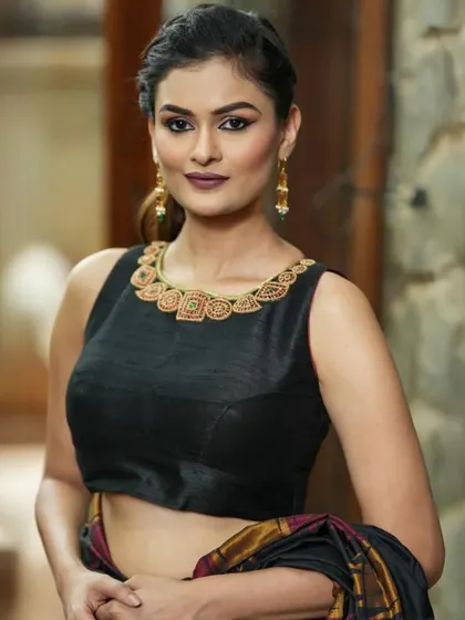 A sleeveless black blouse with an embroidered neckline, a versatile piece for any festive occasion.