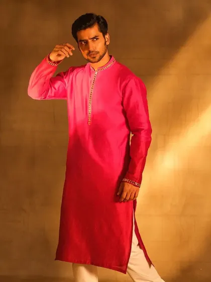A full-length shot for the Nayantaara menswear campaign. The grooming is clean and refined, complementing the vibrant pink ombre kurta and ensuring a polished overall appearance.