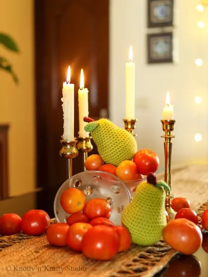 Who says Christmas decor has to follow the rules? I created this festive centerpiece with candles, tomatoes, and my handmade crochet pears for a unique and cozy holiday table.
