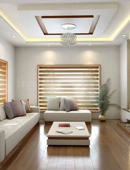 A minimalist living room with clean lines and a neutral color palette. The stone accent wall for the TV and the wooden flooring add natural texture and warmth.