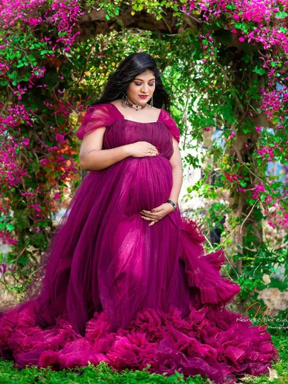 Another stunning shot of the magenta gown, this time with the mother-to-be cradling her bump. The garden setting makes the colors pop even more.