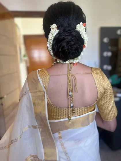 A simple and elegant messy bun decorated with fresh jasmine. This is a classic choice for a Kerala bride or for any bride wanting a sophisticated look.