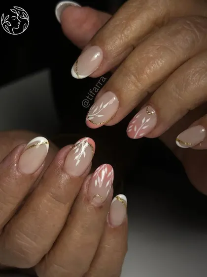 Elegance is in the details. This intricate design with delicate white leaves and a touch of gold was created for a bride's mother on short gel extensions. We teach art that is adaptable to any nail length and occasion.