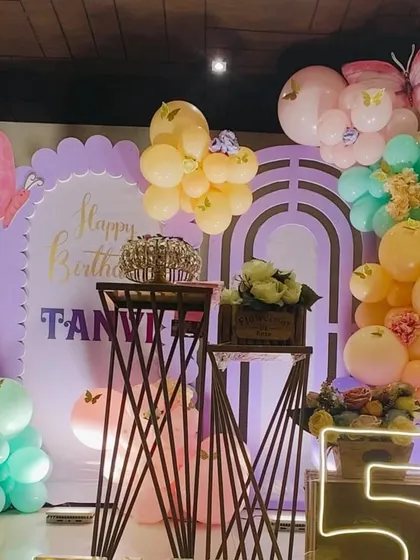 A detailed shot of the dessert stands and marquee number "5" for the butterfly party.