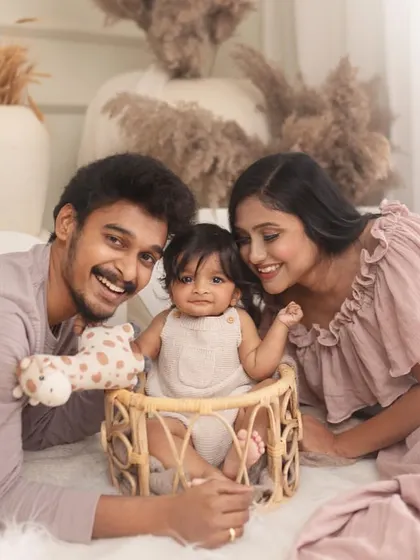 A proud mom and dad with their baby during a sitter session. Including parents in milestone shoots creates beautiful memories of this special time for the whole family.