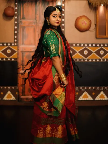 A side profile shot capturing the movement of the hair and the elegance of the saree.
