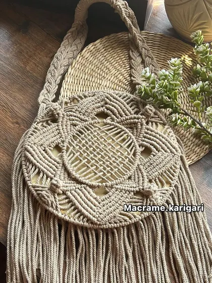 The same round macramé beach bag design in a classic beige. This neutral color is versatile and showcases the detailed knot work and texture of the natural cotton cord.