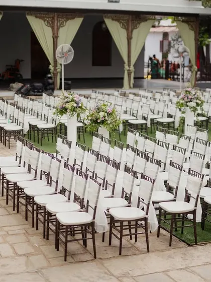 Guest seating arranged for a ceremony, with simple white bows on the chairs.