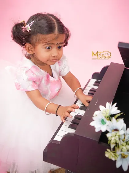 Deep in concentration, this little girl is focused on the piano keys. It's these quiet, focused moments that show a child's budding personality.