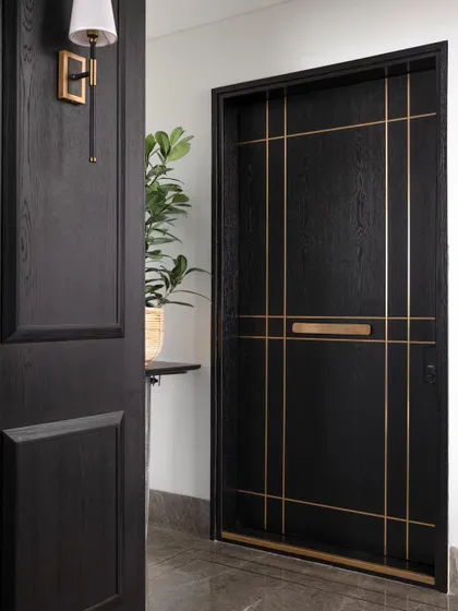 The main door of the apartment, featuring a custom design with elegant brass inlay. The entrance sets the tone for the beautifully detailed home within.