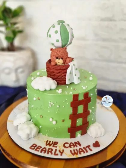 A different take on the "bearly wait" theme, this time with a teddy in a hot air balloon. The fresh green color and fondant clouds make it a unique choice for a baby shower.