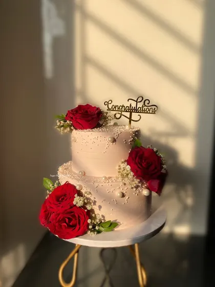 A beautiful 3kg Chocolate Truffle cake made with rich couverture ganache for a celebration. The cake is adorned with fresh red roses and baby's breath for a classic, elegant finish.