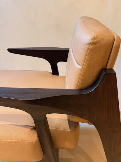 This detail shot showcases the sculpted armrest and the smooth finish of the leatherette cushion, illustrating the beautiful contrast between the materials.