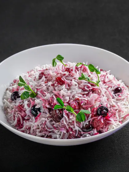 A unique berry pulao, with white rice tossed with cranberries and blueberries, offering a fusion of flavors.