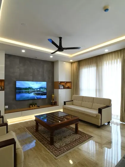 A modern living room with a custom TV unit featuring a concrete-finish back panel. The clean lines of the furniture and the minimalist decor create a sophisticated and uncluttered environment.