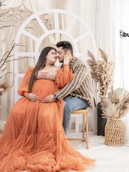 A tender moment in our earthy, elegant studio setup. The natural light and boho decor create a perfect, romantic setting for a maternity photoshoot.