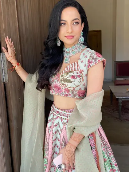 For this bride's Mehendi, I created soft, natural-looking waves that complement her beautiful pastel lehenga and floral jewelry.
