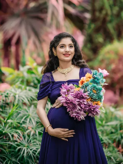 An elegant dark blue gown with delicate puff sleeves. This classic style is flattering and timeless, perfect for a solo portrait in a beautiful garden.