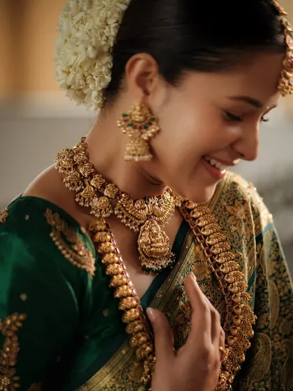 A joyful, candid shot. The warmth of the gold jewellery complements her smile and the festive atmosphere perfectly.