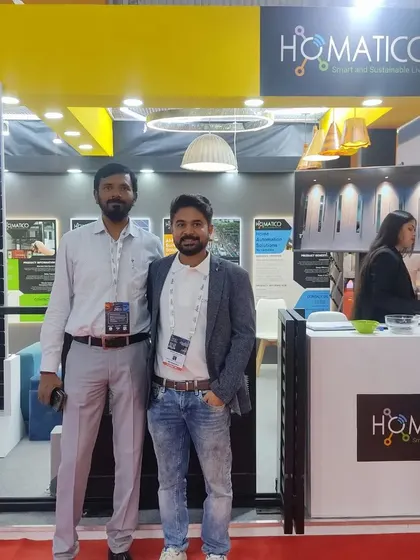 A photo with a partner at our booth, standing next to a display of our high-efficiency solar panels.