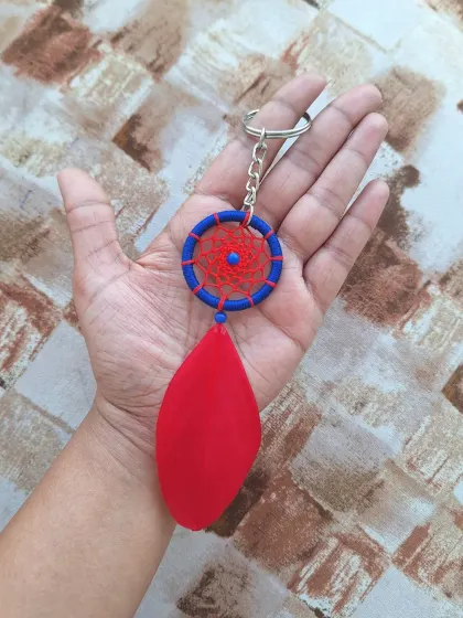 A bold and vibrant dreamcatcher keychain in red and blue with a solid red feather. This piece is perfect for someone who loves a pop of primary color.