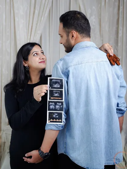 Sharing the journey from the very first scans. This creative shot shows the couple looking back at their baby's ultrasound pictures, a beautiful way to tell the story of their pregnancy.
