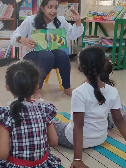 The storyteller uses her hands to animate the story of the butterfly's life cycle.