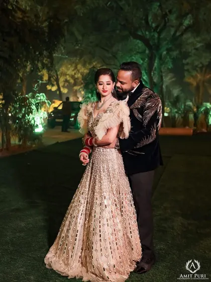 A romantic reception portrait in a garden setting. The groom's embrace and the bride's stunning gown create a scene straight out of a romance novel, full of elegance and affection.
