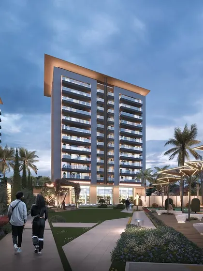 Another evening view of Gulnaar Zenium, emphasizing the warm interior lighting visible through the expansive balconies, creating a sense of a vibrant community.