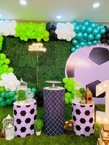 A closer look at the football-themed setup, highlighting the custom pedestals and the large marquee number '1' against the green turf.