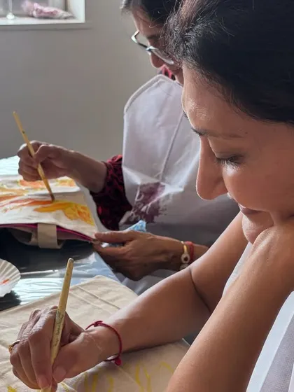 A guest enjoying a relaxed tote bag painting session at a private home event. It's a perfect activity for a chill afternoon with friends.