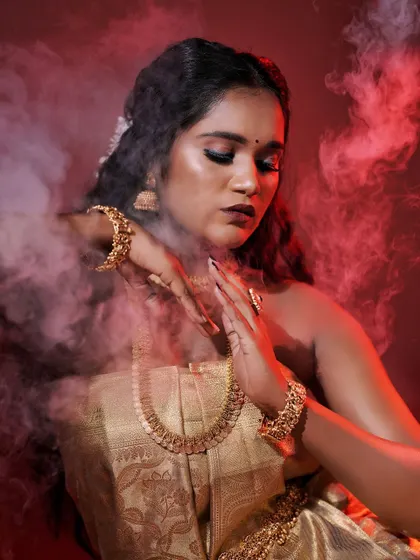 An artistic shot with smoke, creating a mystical and powerful image. The makeup remains the focal point, highlighting her beautiful features.