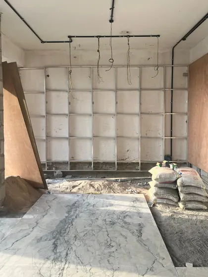 A work-in-progress view from one of our sites. The installation of marble flooring and the framing for future shelving units mark a critical phase where the design begins to transition from plan to physical form.