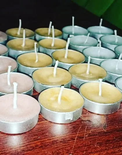 A batch of my handmade tealight candles, ready for packing. You can see the different colored waxes I use, including pink, yellow, and white, available for bulk orders.