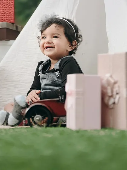 A close-up of a happy little girl enjoying her birthday shoot. Her bright smile and the soft background create a beautiful, heartwarming portrait.