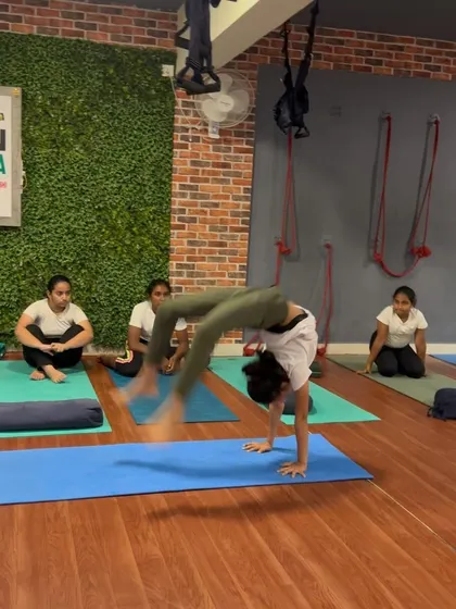 A dynamic entry into Chakrasana, this student shows both flexibility and explosive strength.