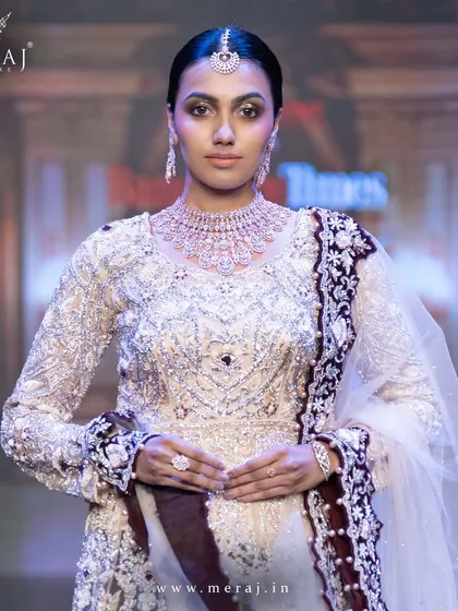 A close-up of the light peach and wine Indo-Western bridal lehenga, showcasing the intricate zardosi hand embellishments.