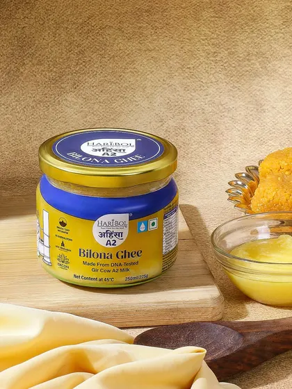 This shot pairs the Bilona Ghee with traditional Indian sweets like laddoos. The warm lighting and earthy textures highlight the ghee's role in preparing festive delicacies, evoking a sense of homemade goodness.