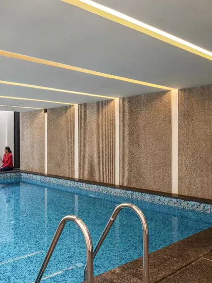 An indoor swimming pool offers a year-round escape. This design uses textured walls and strategic lighting to create a serene and private atmosphere, perfect for both exercise and relaxation.