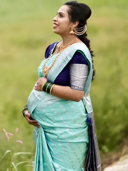 A beautiful shot capturing the side profile and the traditional braided hairstyle with hair accessories, perfect for a seemantha ceremony.
