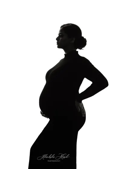 A simple, clean silhouette against a white background. This minimalist fine art style is incredibly powerful, focusing purely on the beautiful form of the mother and child.