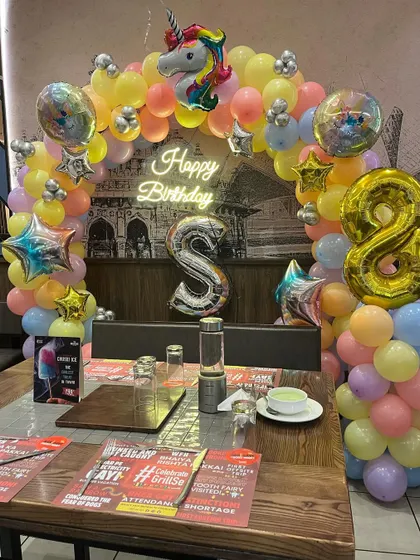 The complete table setup for an 8th birthday with a unicorn theme, ready for the cake cutting ceremony.