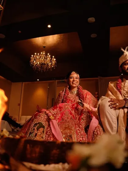 A beautiful wide shot of the couple during their wedding ceremony, with the sacred fire burning in the foreground.