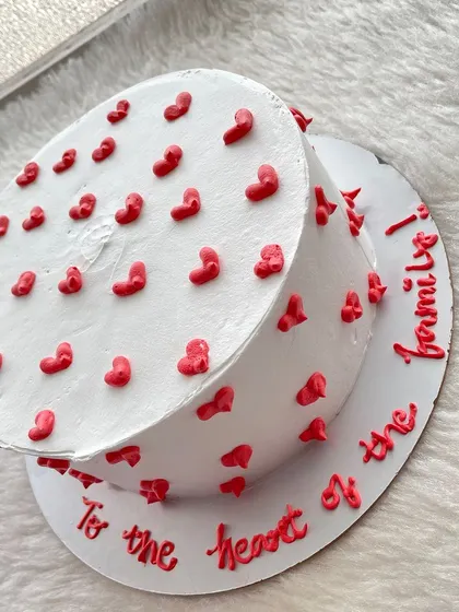 Sometimes, simple is best. This white cake is covered in tiny red hearts, with a sweet message piped around the base.