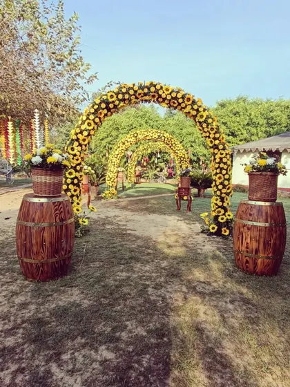 A grand entrance to a Haldi event, marked by arches made entirely of sunflowers, creating a stunning visual impact.