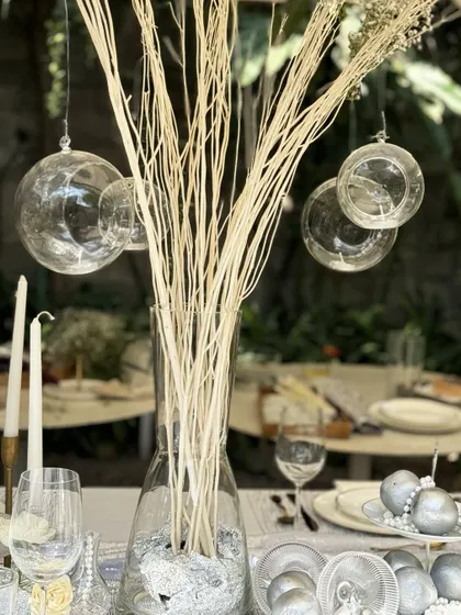 A closer look at the details from our workshop tablescape. Hanging glass orbs, tall taper candles, and scattered pearls on the table create layers of texture and light, showing how to build a truly luxurious and multi-dimensional setting.